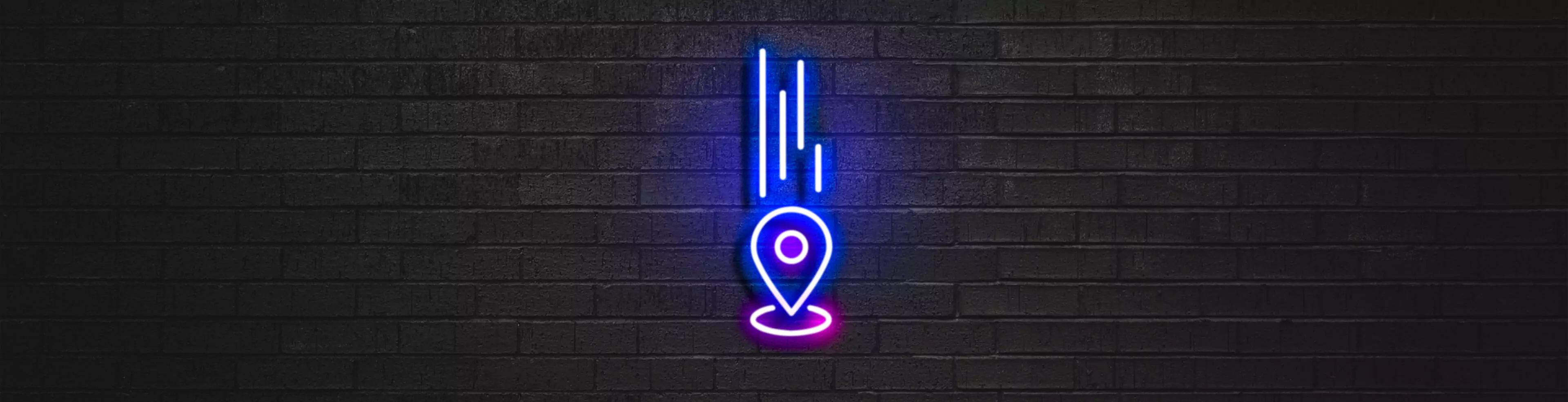 Neon de pin de localização iluminando uma parede de tijolos escura